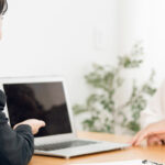 老年女性にパソコンを使って説明をするビジネスマン