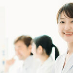 何名かの医師と集まりながら微笑む女性医師