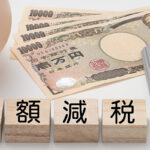 定額減税という文字と電卓・紙幣・貯金箱