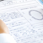 歯科の問診票を見つめる人の手元