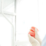 歯の模型を使いながら説明する歯科クリニックのスタッフと話を聞く患者