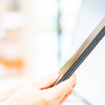 決済端末にスマホを近づける人の手元